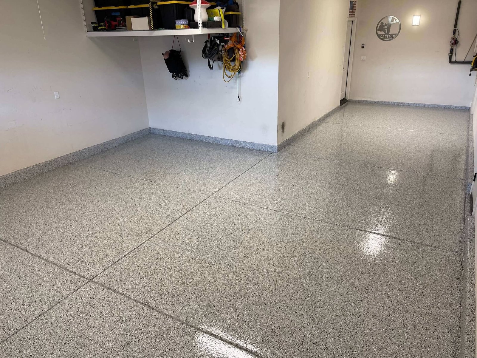 Finished gray flake epoxy garage floor with a glossy polyaspartic topcoat installed by Best Coast Epoxy Coatings