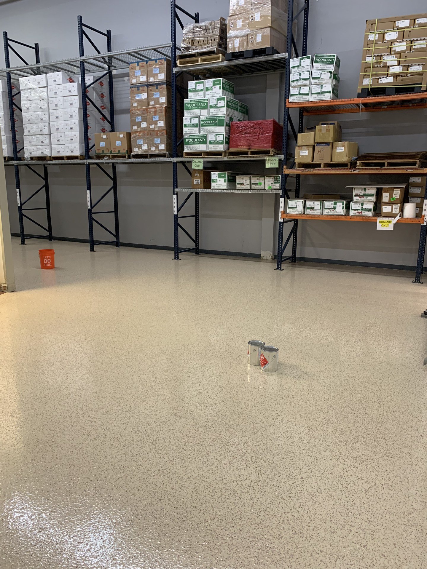 Finished tan flake epoxy floor in a commercial warehouse with pallet racking