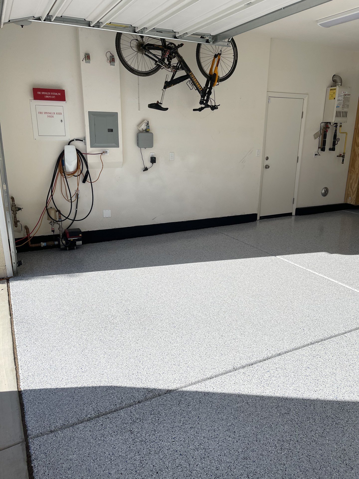 Flake garage floor coating with the garage door open and a bike hung on the wall