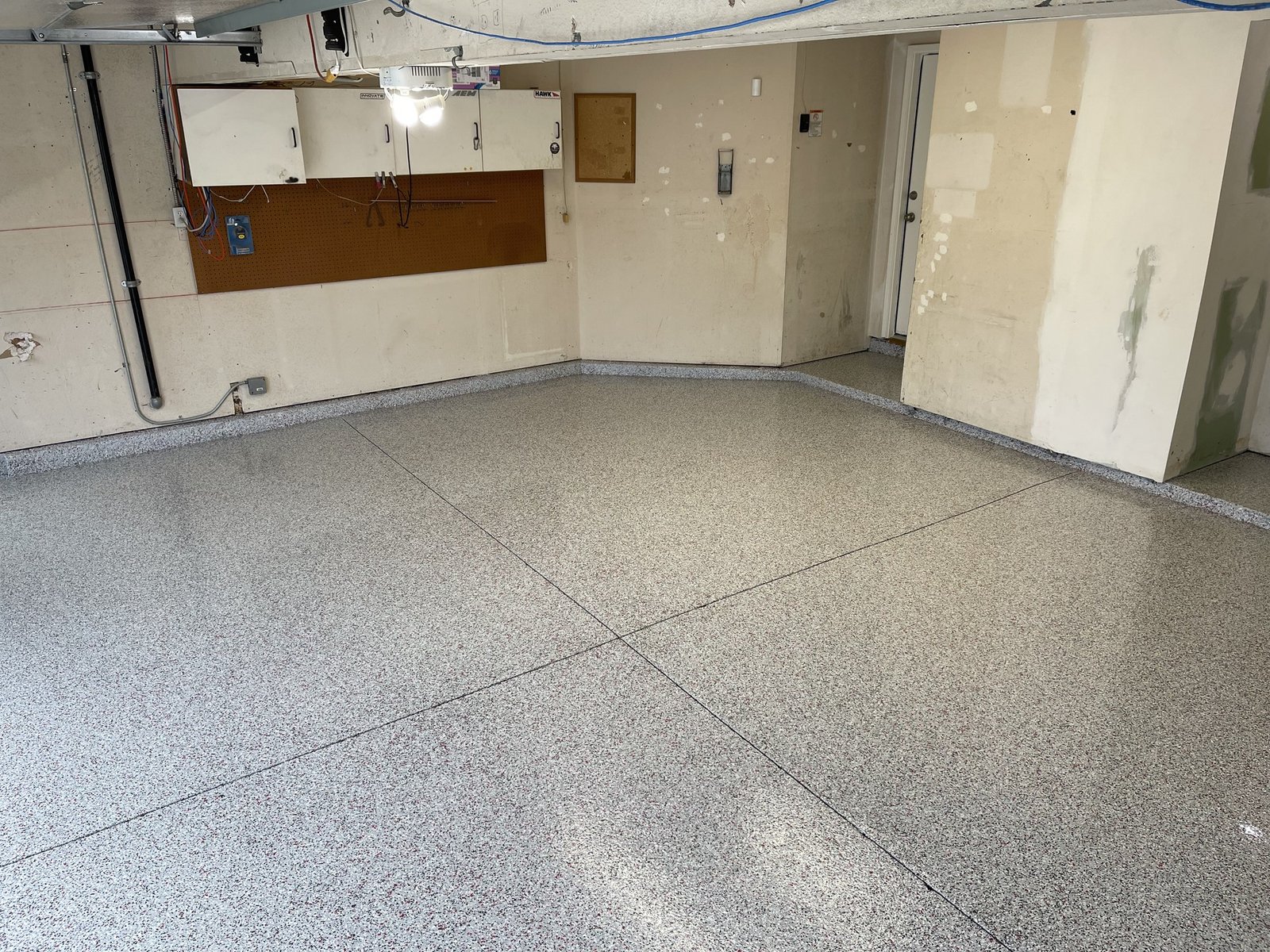 Two-car garage with a gray flake floor coating and a coated stem wall border