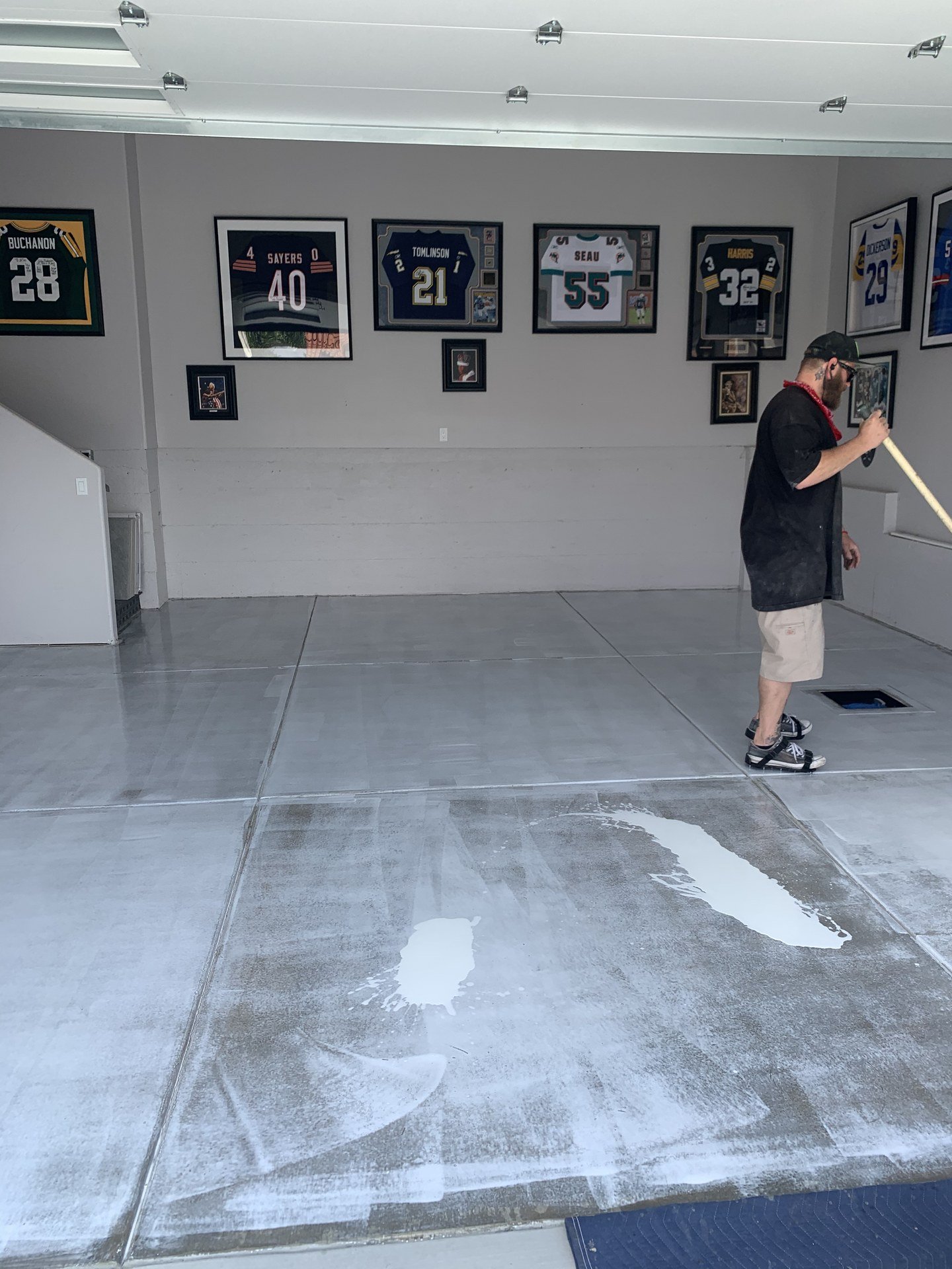 Best Coast installer rolling a coat onto a prepared garage floor
