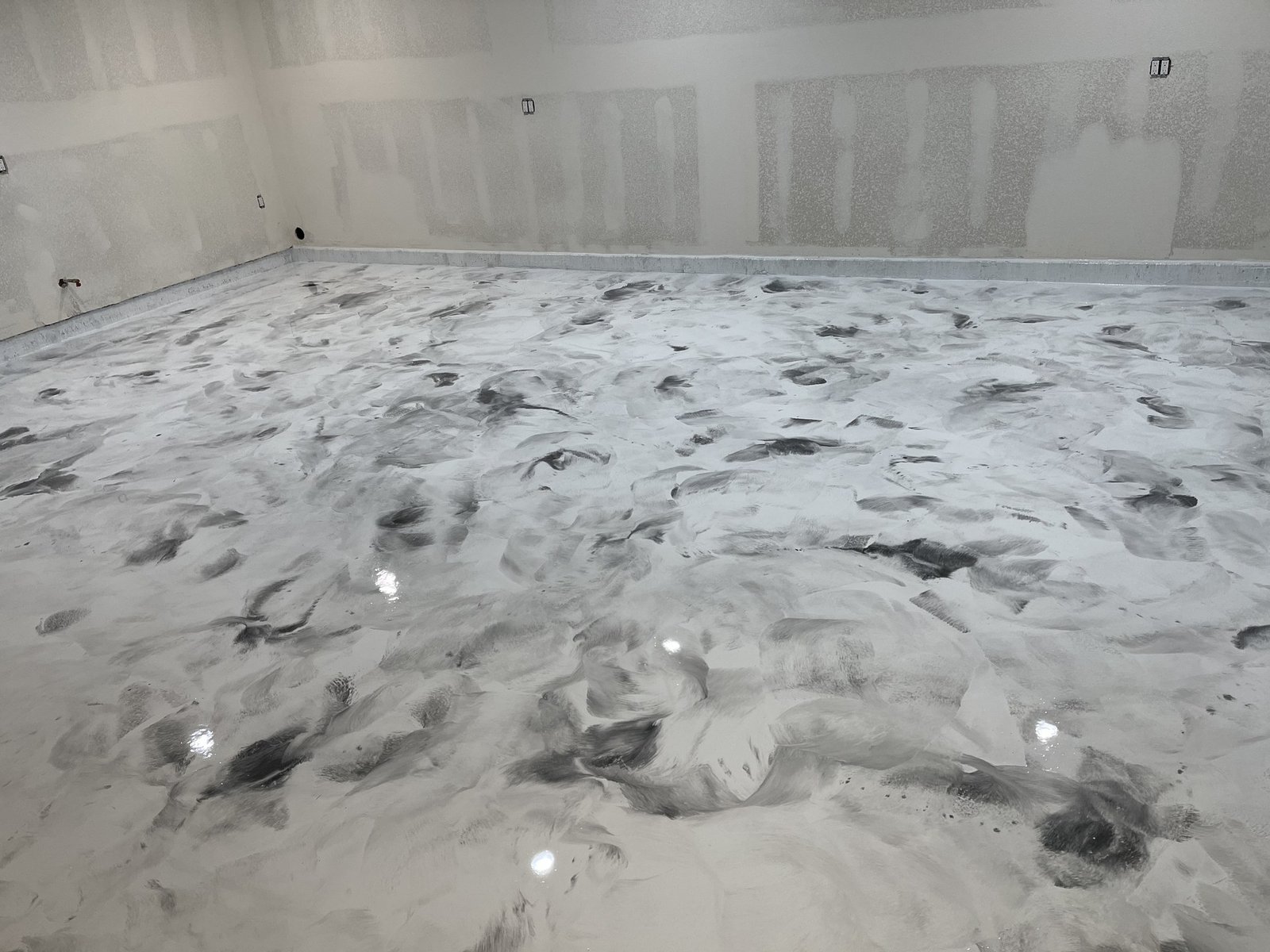 White and gray metallic epoxy floor with a marbled swirl finish