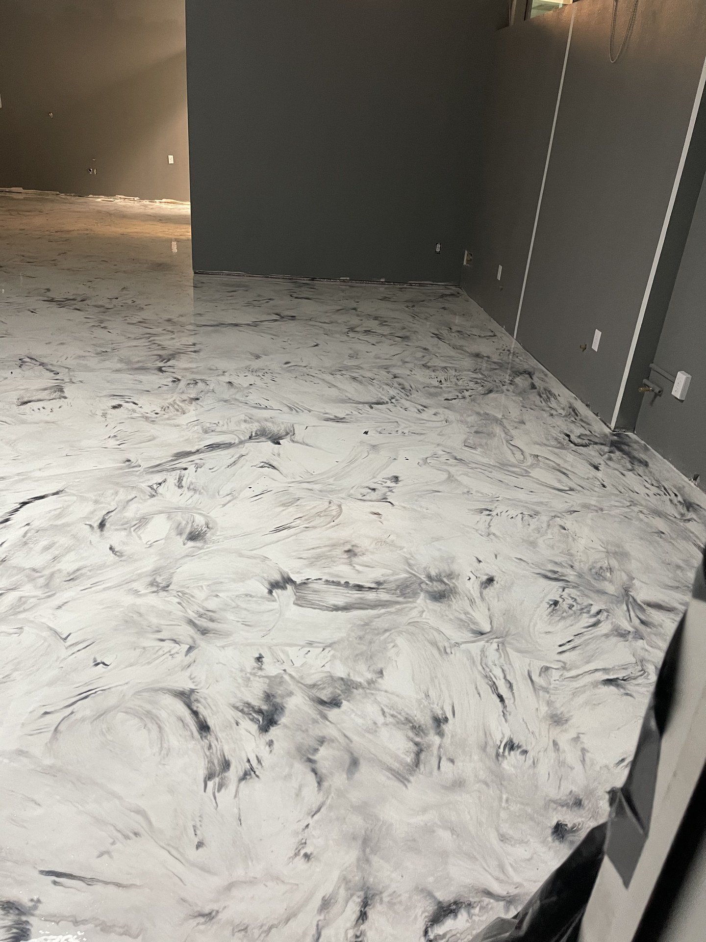 White metallic epoxy floor with gray marble swirls